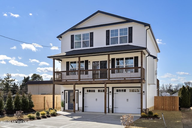 view of front of property featuring driveway, a garage, and fence