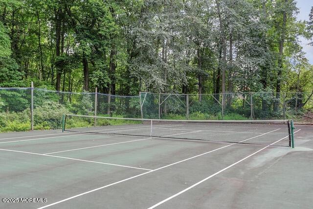 view of tennis court with fence