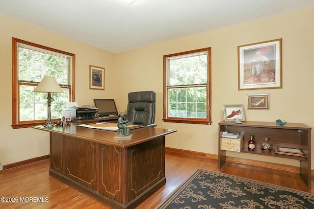 home office with baseboards and wood finished floors