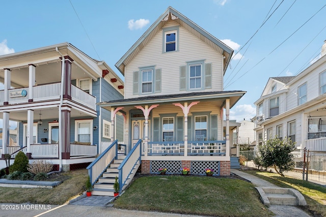 view of front facade with a porch, a front lawn, and fence