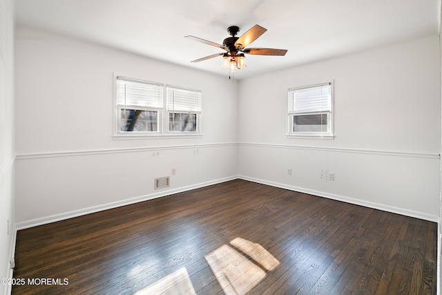 unfurnished room featuring visible vents, baseboards, a ceiling fan, and dark wood-style flooring