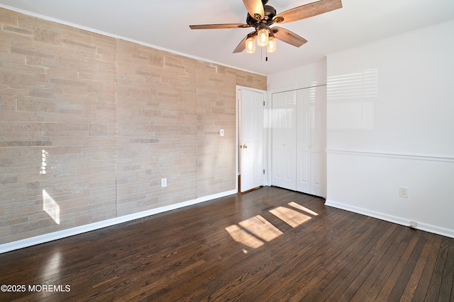 unfurnished bedroom with baseboards, dark wood-style flooring, a closet, and ceiling fan