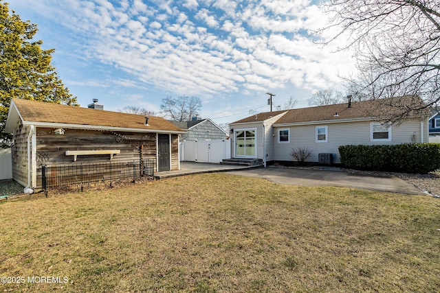 rear view of property featuring fence, central air condition unit, entry steps, a yard, and a patio