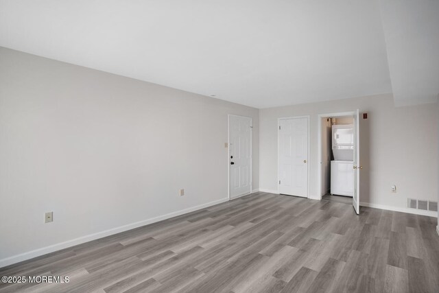 unfurnished room featuring wood finished floors, visible vents, and baseboards