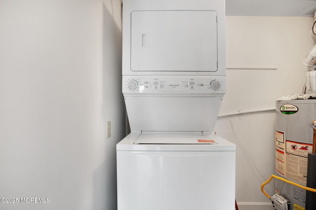 washroom featuring gas water heater, laundry area, and stacked washing maching and dryer