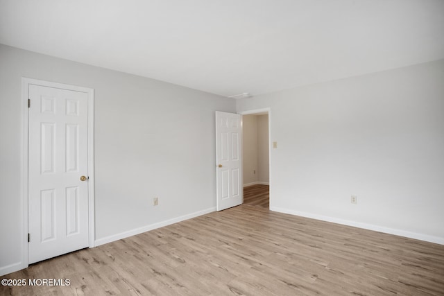 empty room featuring wood finished floors and baseboards