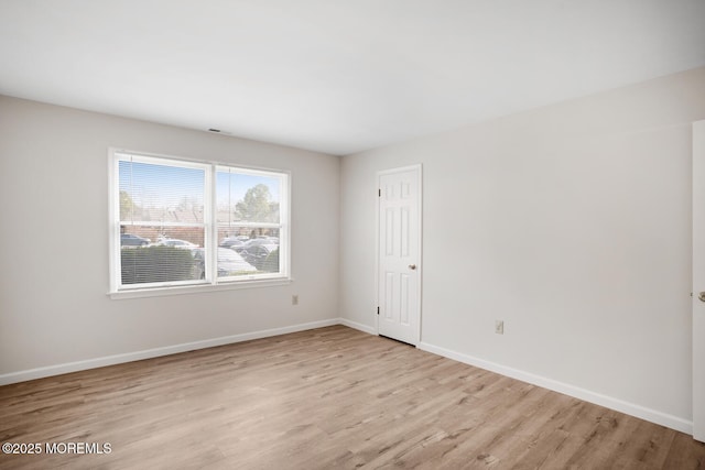 empty room with baseboards and wood finished floors