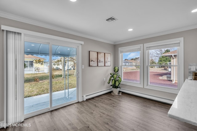 unfurnished dining area featuring a baseboard radiator, wood finished floors, visible vents, and ornamental molding