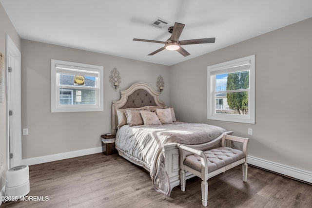 bedroom featuring visible vents, ceiling fan, baseboards, baseboard heating, and light wood-style floors