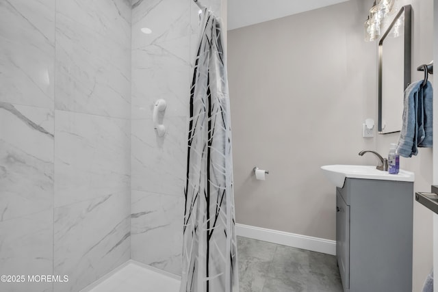 bathroom featuring curtained shower, vanity, and baseboards