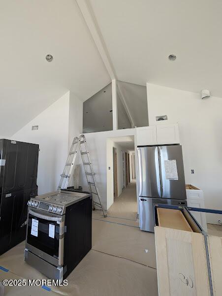 kitchen featuring a center island, concrete flooring, stainless steel appliances, white cabinets, and high vaulted ceiling