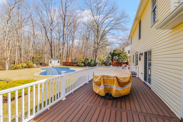 wooden deck featuring an outbuilding and a lawn