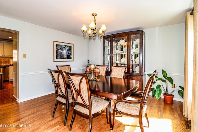 dining area with light wood-style flooring, visible vents, baseboards, and a chandelier