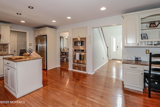 kitchen with a warming drawer, light wood finished floors, recessed lighting, and appliances with stainless steel finishes