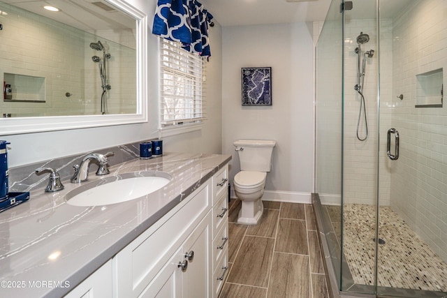 full bathroom with baseboards, a stall shower, and wood finish floors