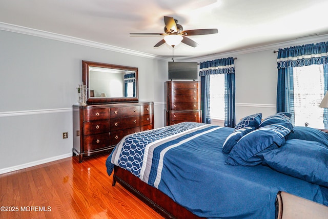 bedroom with visible vents, wood finished floors, baseboards, and ornamental molding