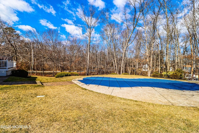 view of pool with a covered pool and a lawn