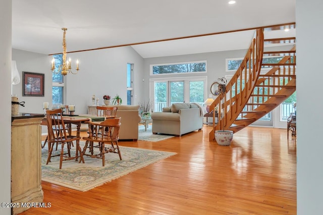 dining area featuring stairs, lofted ceiling, light wood-style floors, and a chandelier