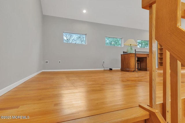 interior space featuring light wood-style floors, baseboards, and a healthy amount of sunlight