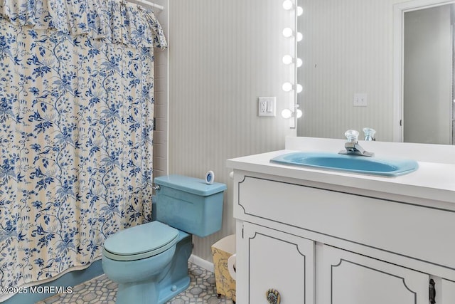 bathroom featuring toilet, vanity, and a shower with curtain