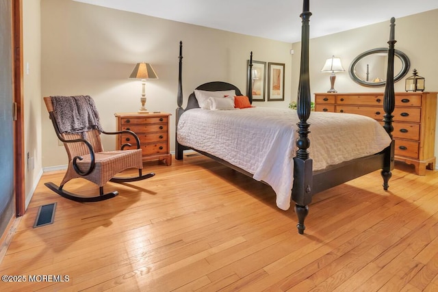 bedroom with visible vents and hardwood / wood-style floors