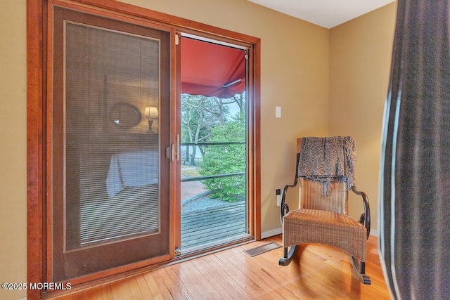 sitting room with visible vents, wood-type flooring, and baseboards