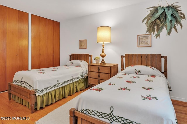 bedroom with two closets and wood finished floors