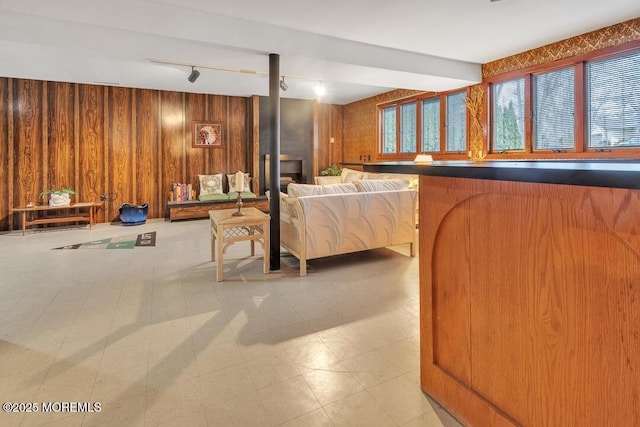 interior space featuring tile patterned floors, wooden walls, and rail lighting