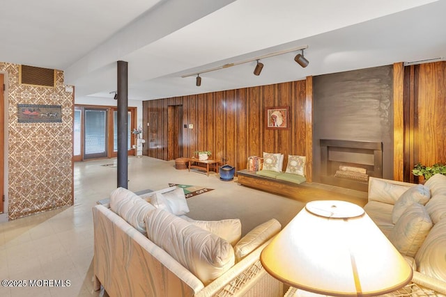 living area with visible vents, track lighting, wood walls, and a fireplace