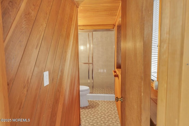 bathroom featuring a shower stall, toilet, and tile patterned floors