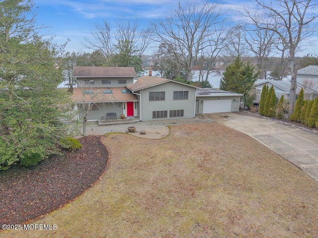 view of front facade with a garage, driveway, and stucco siding