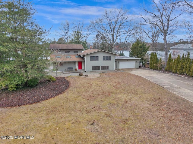 view of front of house with a chimney, a front lawn, concrete driveway, and a garage