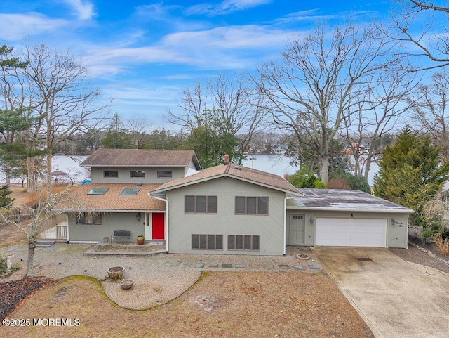 view of front of home featuring an attached garage, driveway, and a patio area