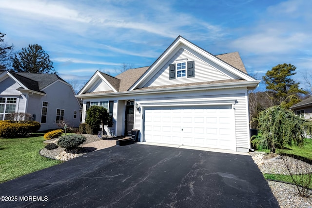 traditional home with aphalt driveway, a garage, roof with shingles, and a front lawn