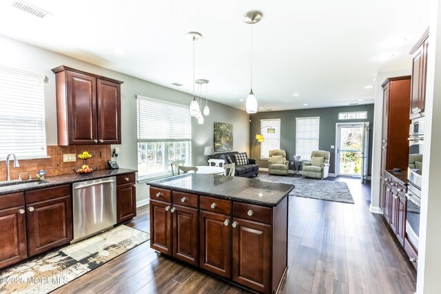 kitchen with dark wood-style flooring, visible vents, appliances with stainless steel finishes, and a sink