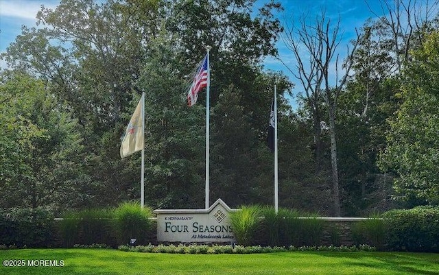 view of property's community featuring a lawn and a view of trees