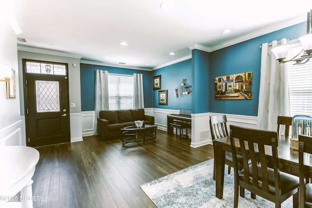 dining room featuring a wainscoted wall, crown molding, visible vents, and wood finished floors