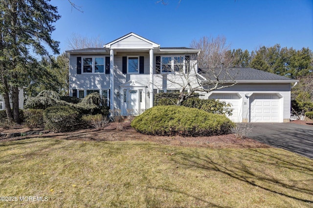 greek revival house with a garage, a front yard, and driveway