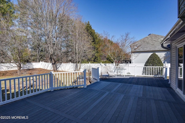 wooden terrace with a fenced backyard