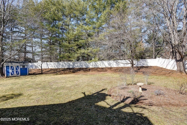 view of yard featuring a storage shed, an outbuilding, and a fenced backyard