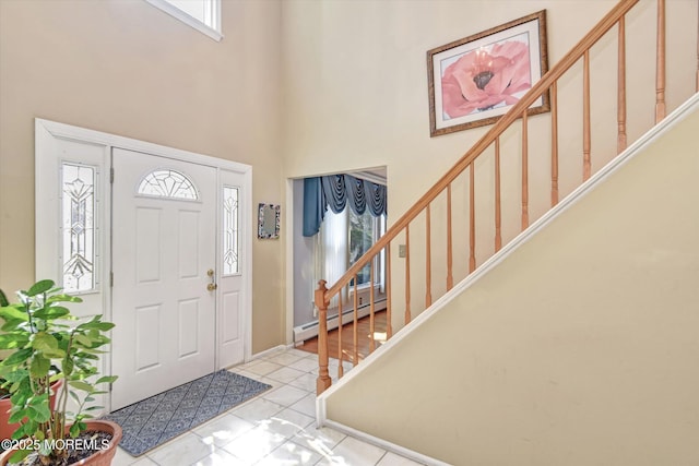 tiled entrance foyer featuring a baseboard heating unit, stairs, and a towering ceiling