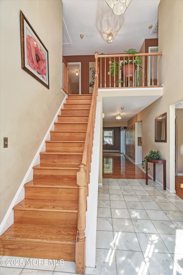 staircase featuring tile patterned floors and baseboards