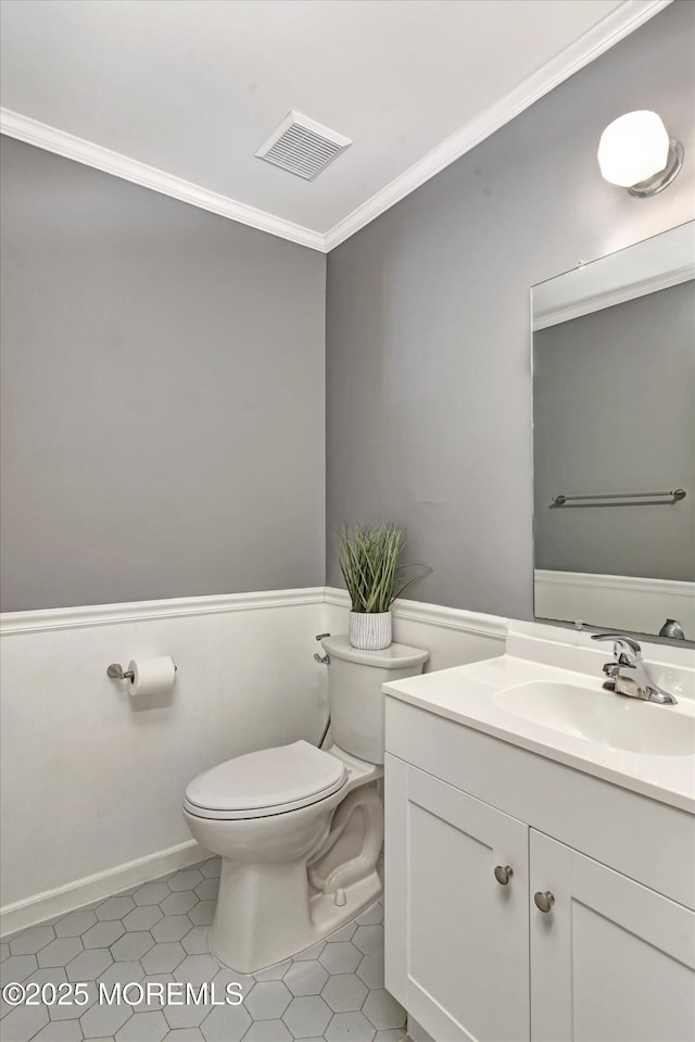 bathroom featuring visible vents, vanity, toilet, and crown molding