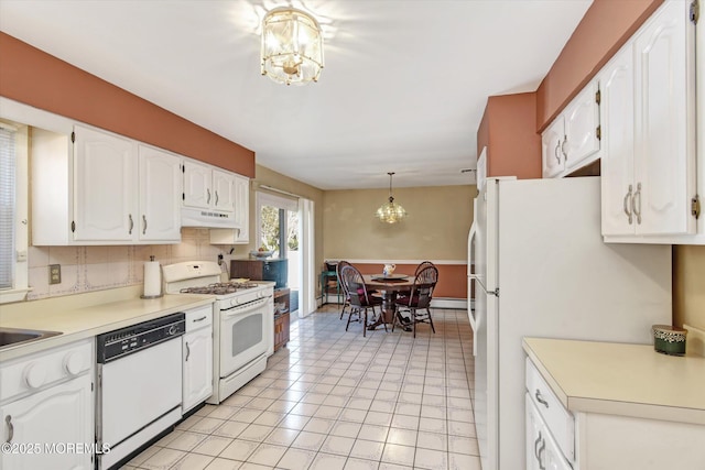 kitchen featuring under cabinet range hood, tasteful backsplash, white appliances, an inviting chandelier, and white cabinets