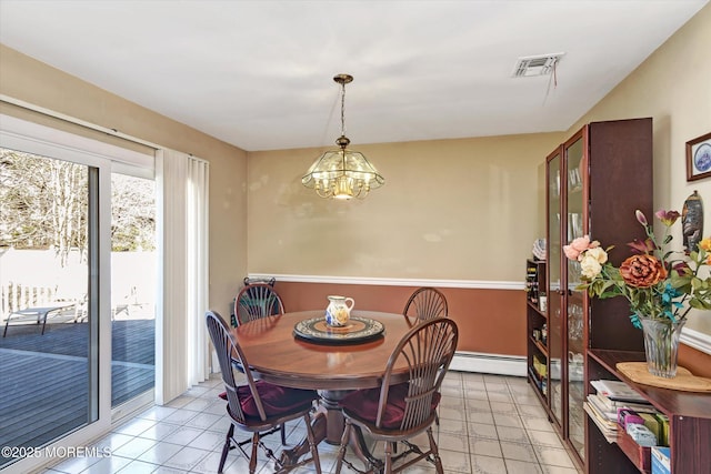 dining space featuring a chandelier, visible vents, and a baseboard heating unit