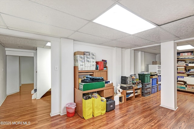 finished basement with a drop ceiling and wood finished floors