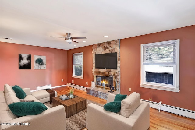 living area featuring visible vents, baseboard heating, and light wood finished floors