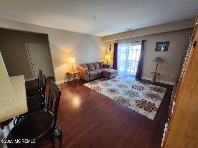 living area with visible vents, baseboards, and wood finished floors