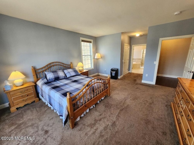 carpeted bedroom featuring ensuite bathroom and baseboards