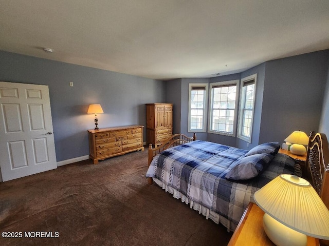 bedroom featuring baseboards and dark carpet